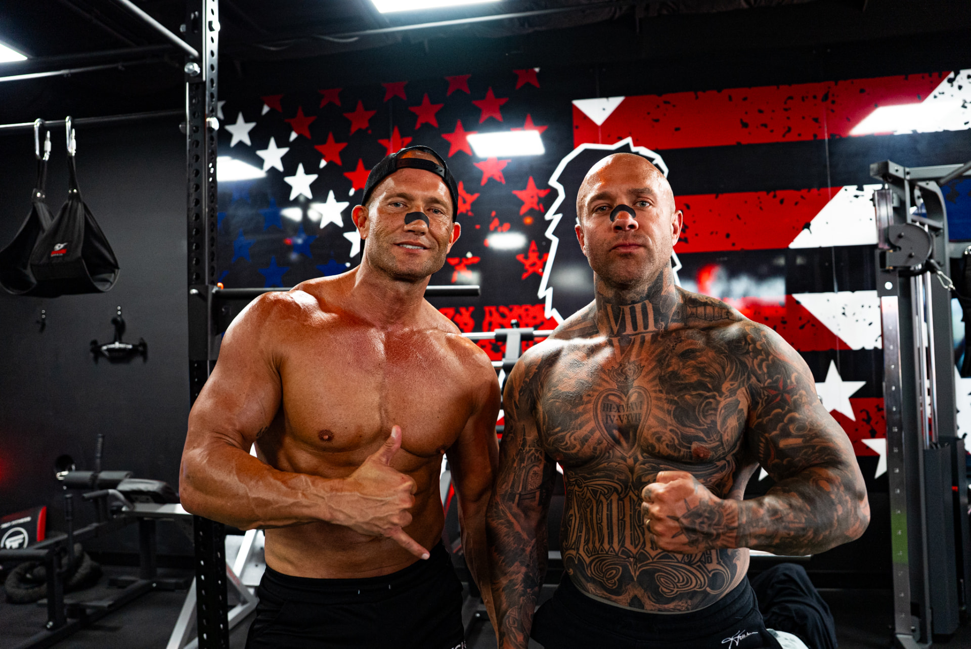 Two athletes posing together in a training gym