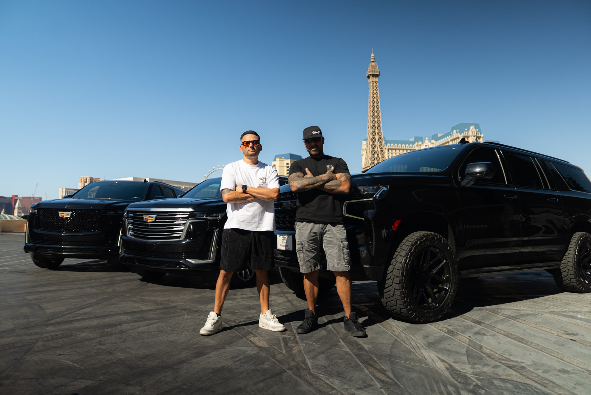 Two men standing with blacked-out SUVs on the Las Vegas Strip