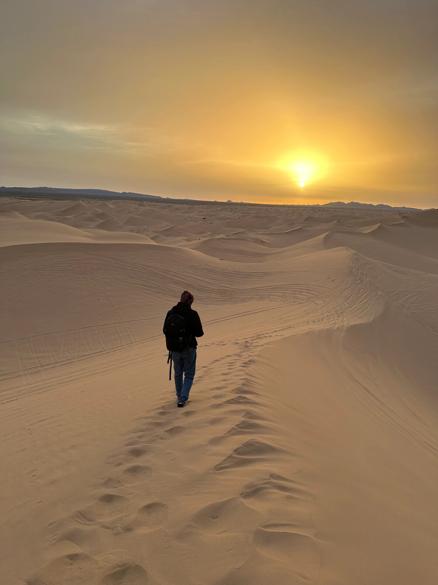 Walking across the sand dunes at sunset