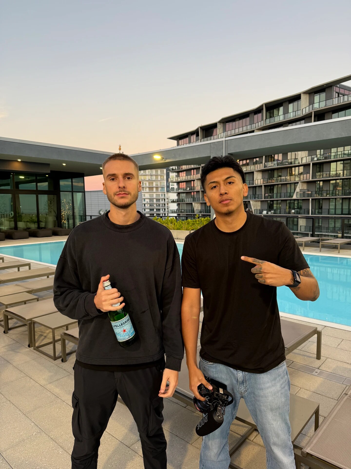 Rooftop pool at sunset with a client
