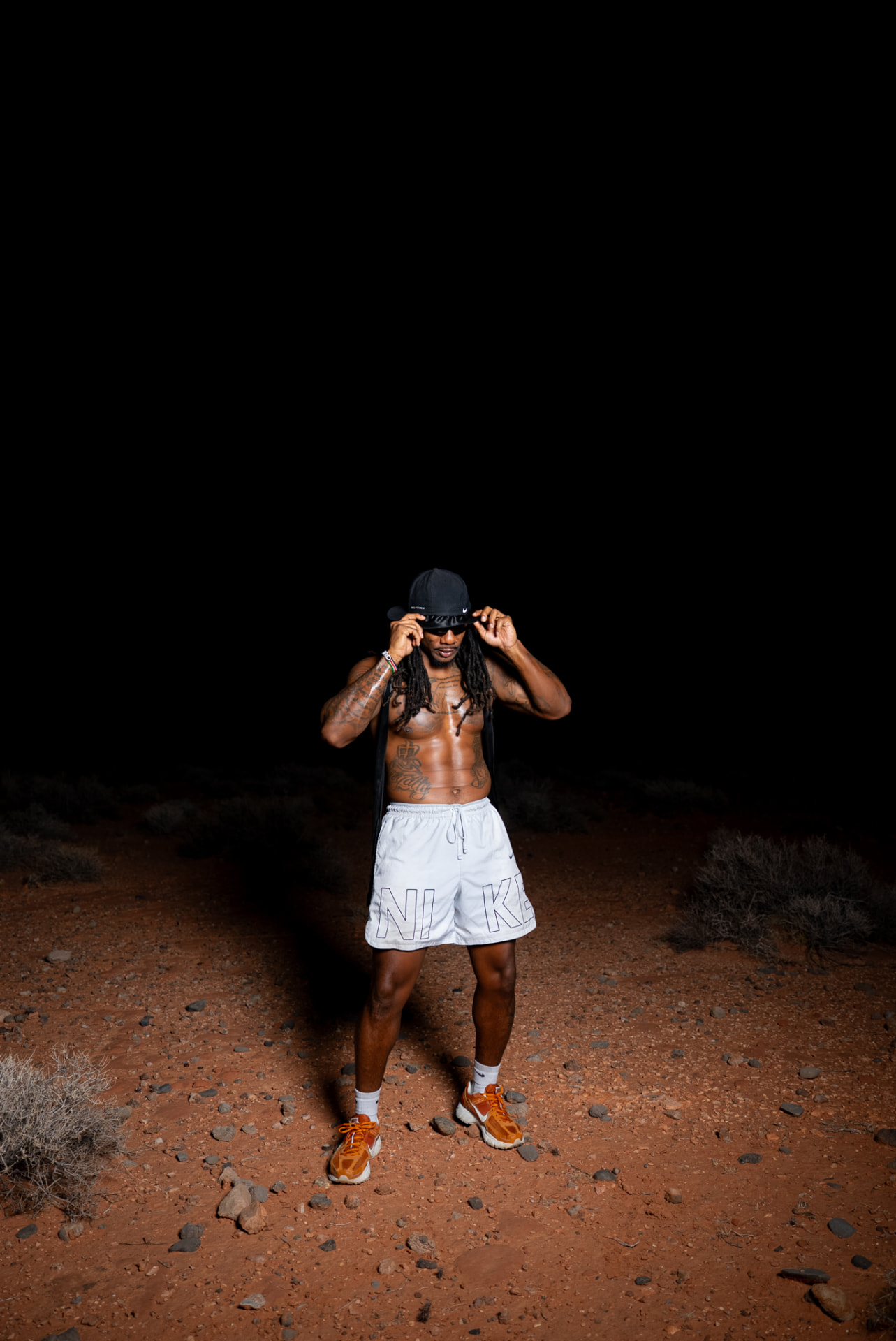 Artist standing on a desert trail at night