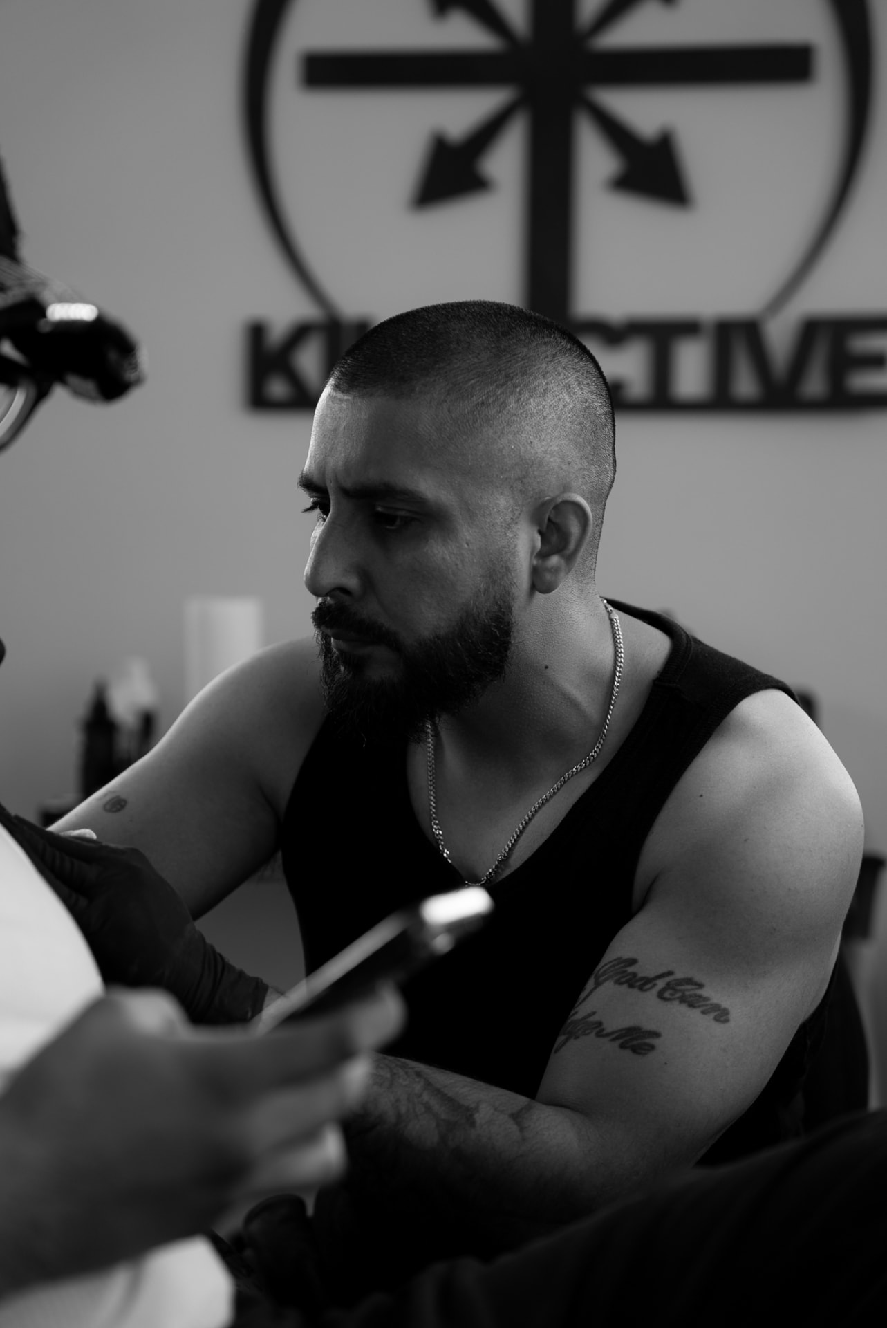 Black-and-white profile of an artist during a tattoo session