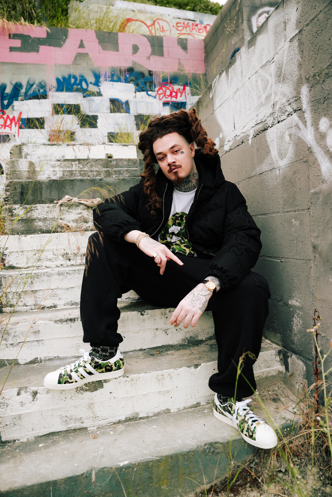 Artist seated on weathered graffiti-covered steps