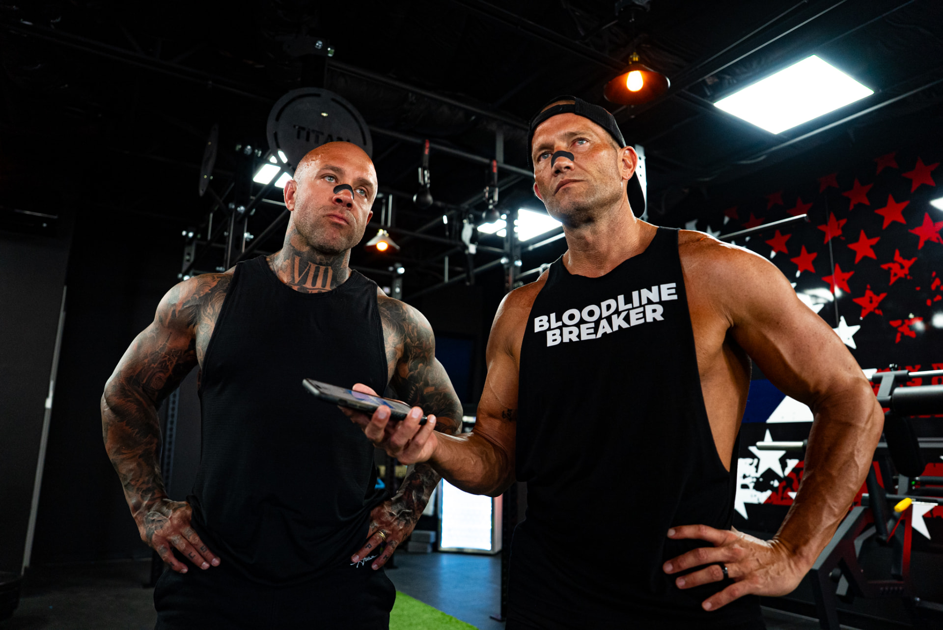 Two athletes talking together inside a training gym