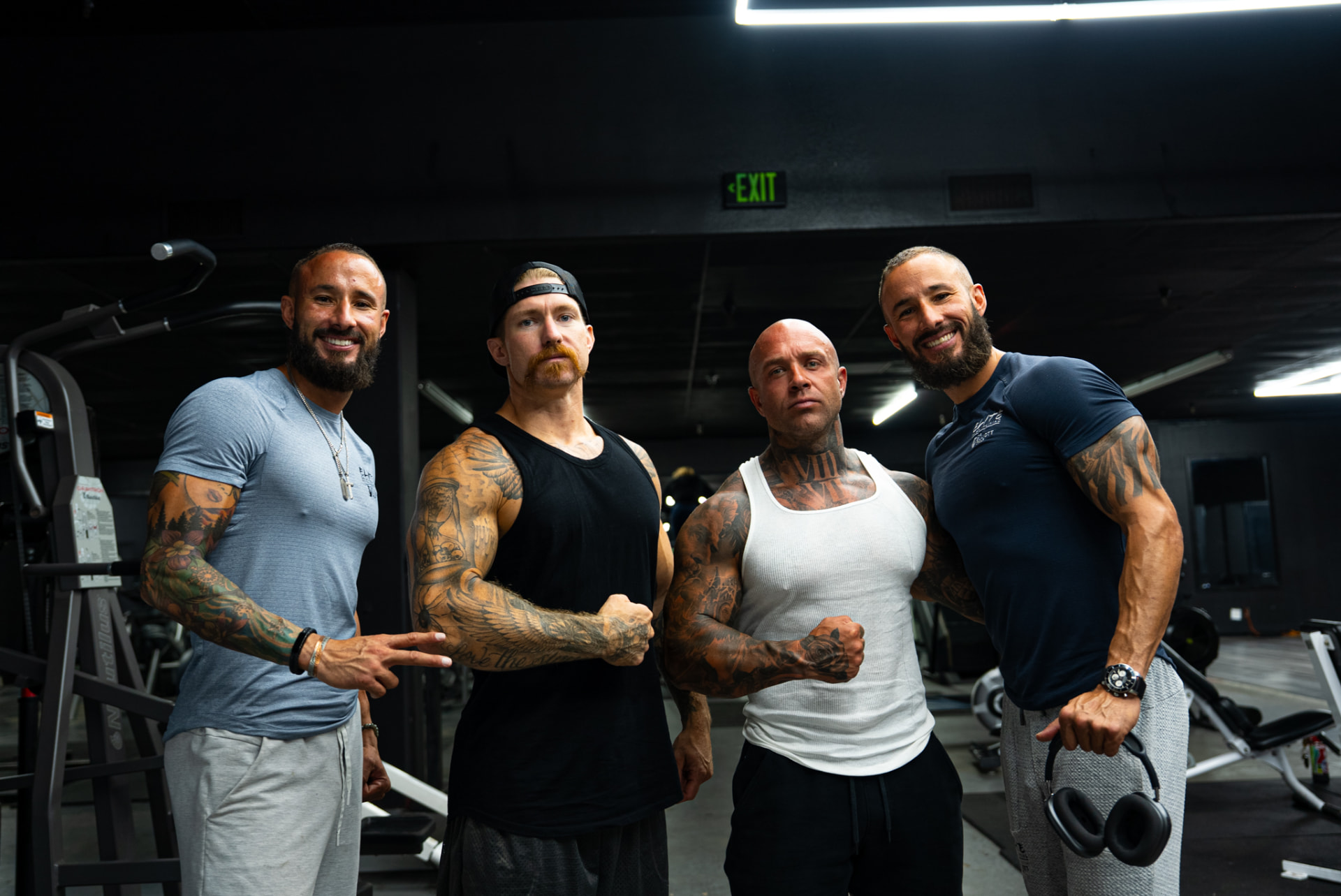 Four athletes posing together in a gym