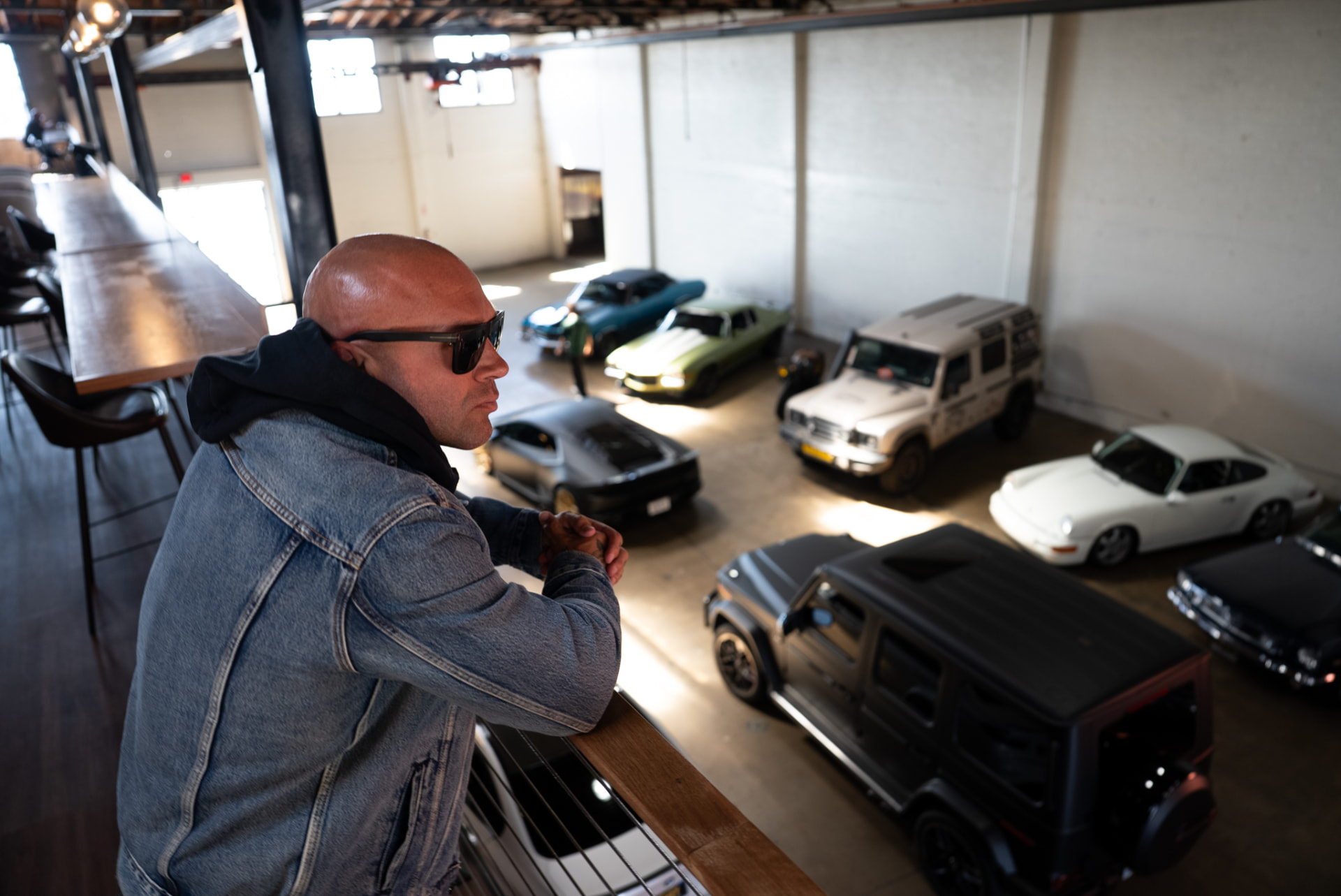 Artist overlooking a showroom floor of luxury cars