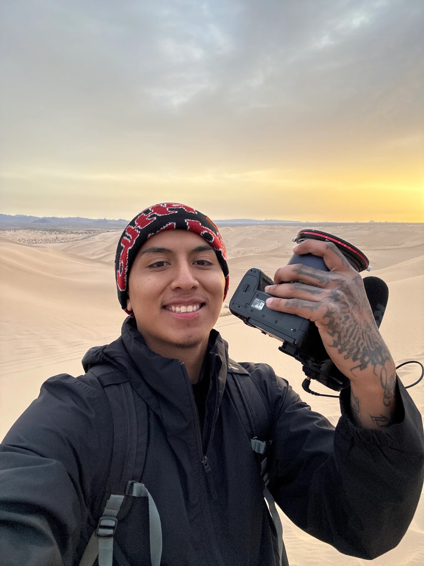 Camera in hand on the sand dunes at sunrise