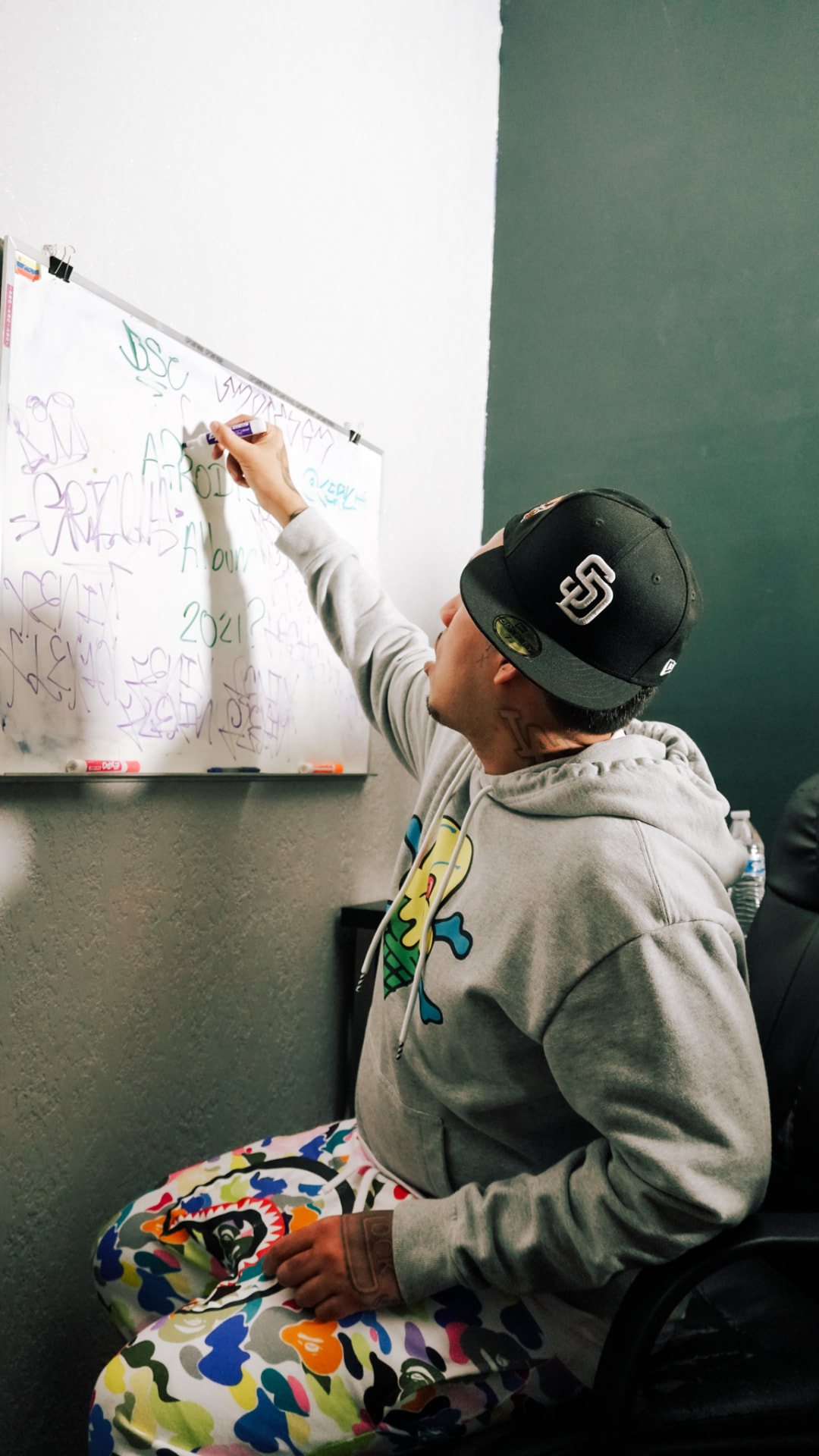 Artist writing tags on a whiteboard during a studio session