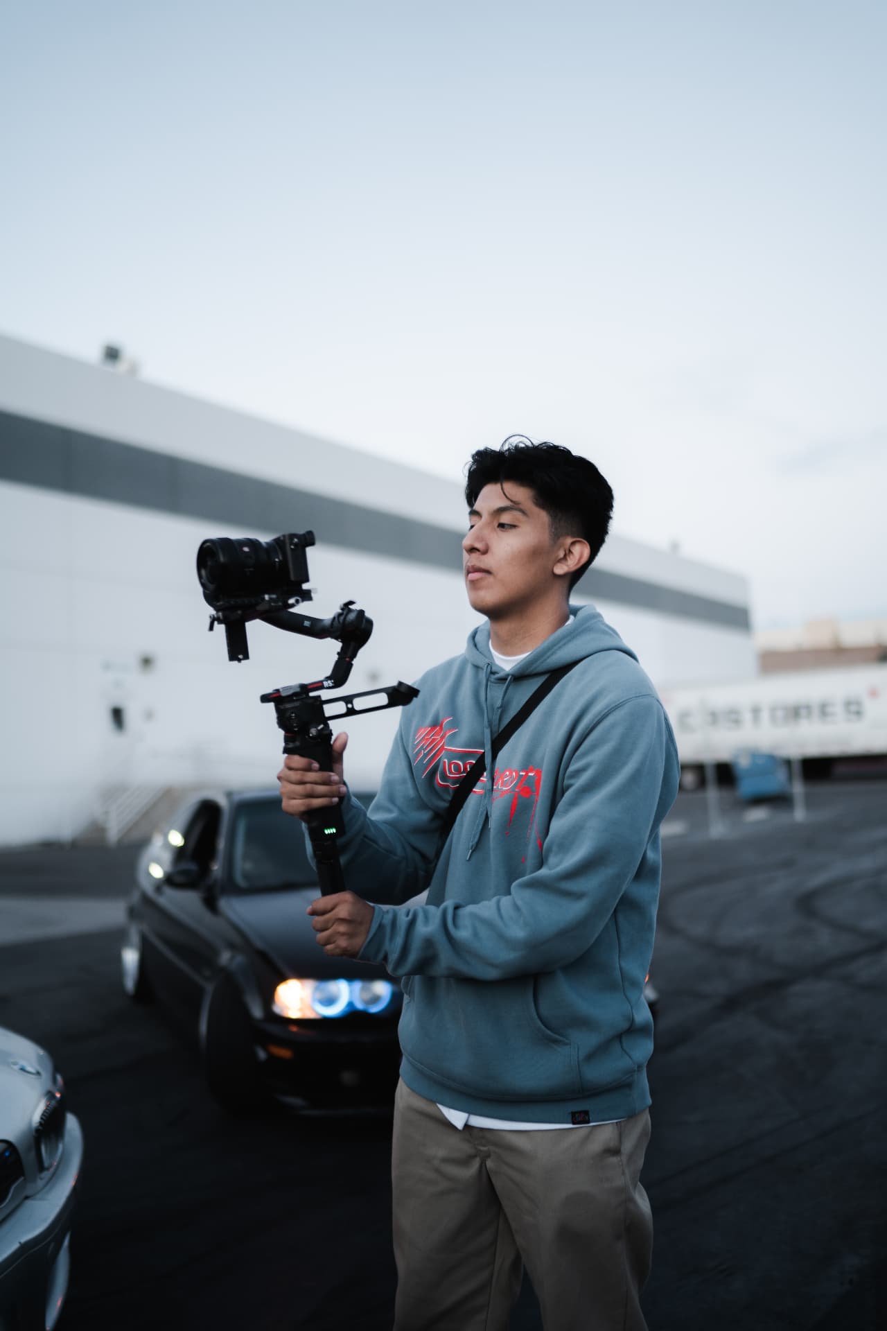 Filming with a gimbal beside cars at dusk