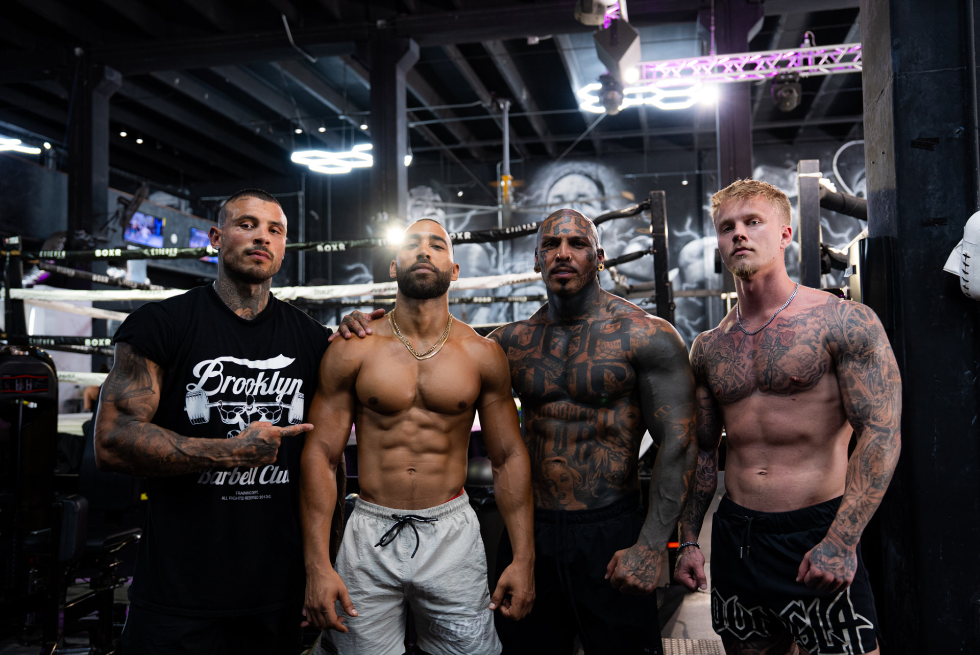 Four athletes standing beside a boxing ring