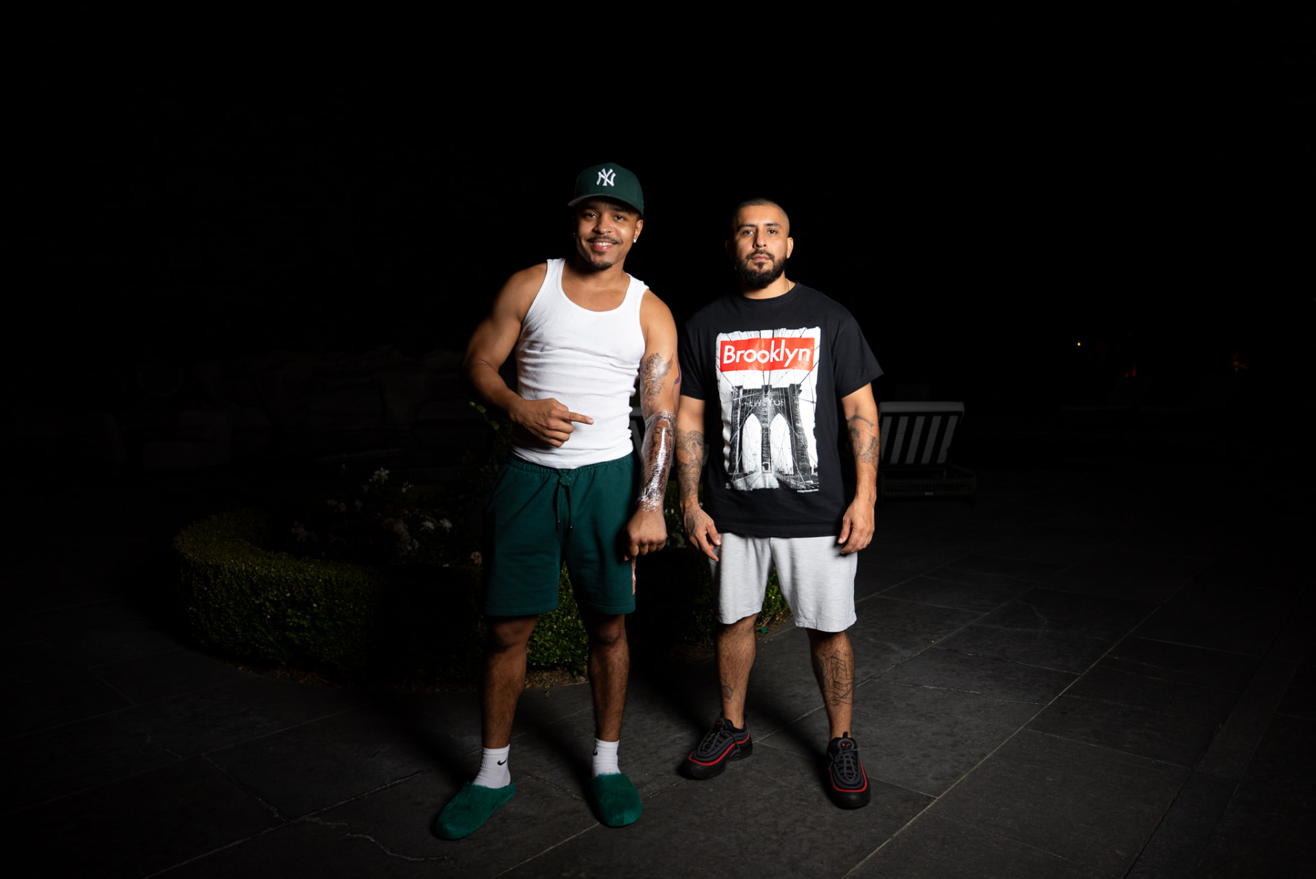 Two men posing outdoors at night under hard flash