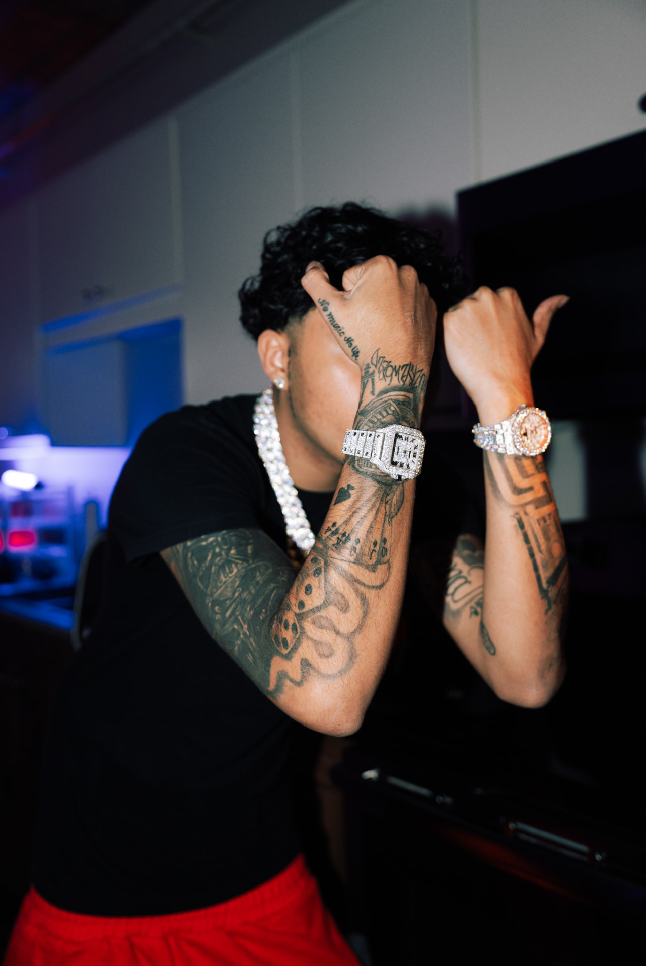 Close portrait of an artist showing diamond jewelry and tattoos