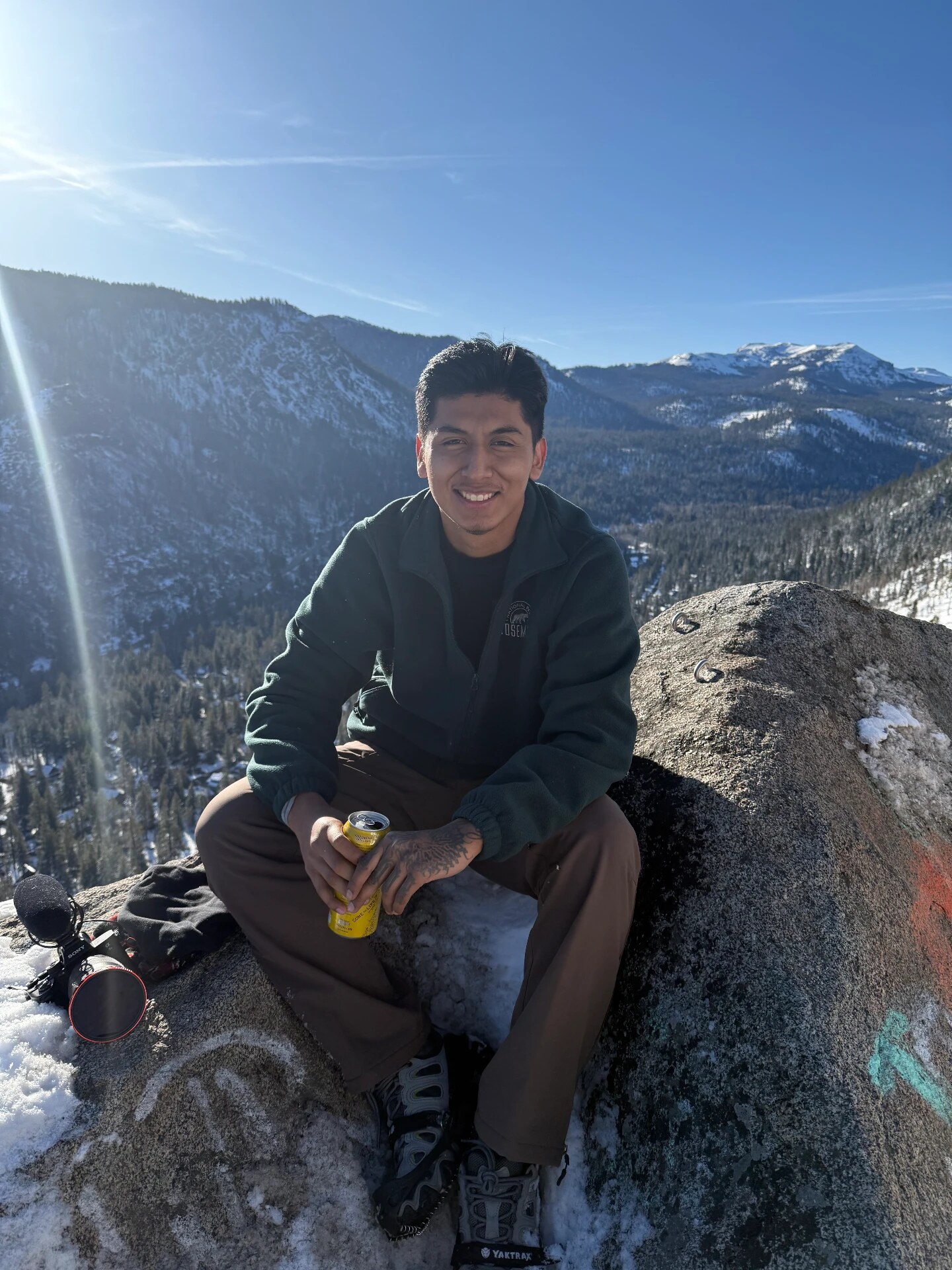 Resting on a snowy mountain overlook with camera gear