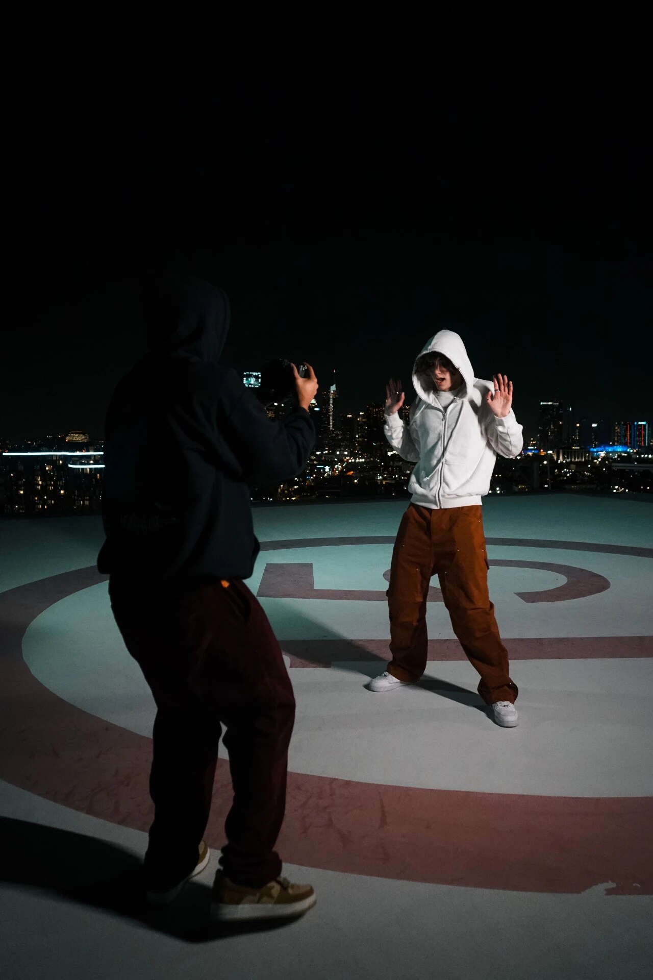 Filming an artist on a rooftop helipad at night